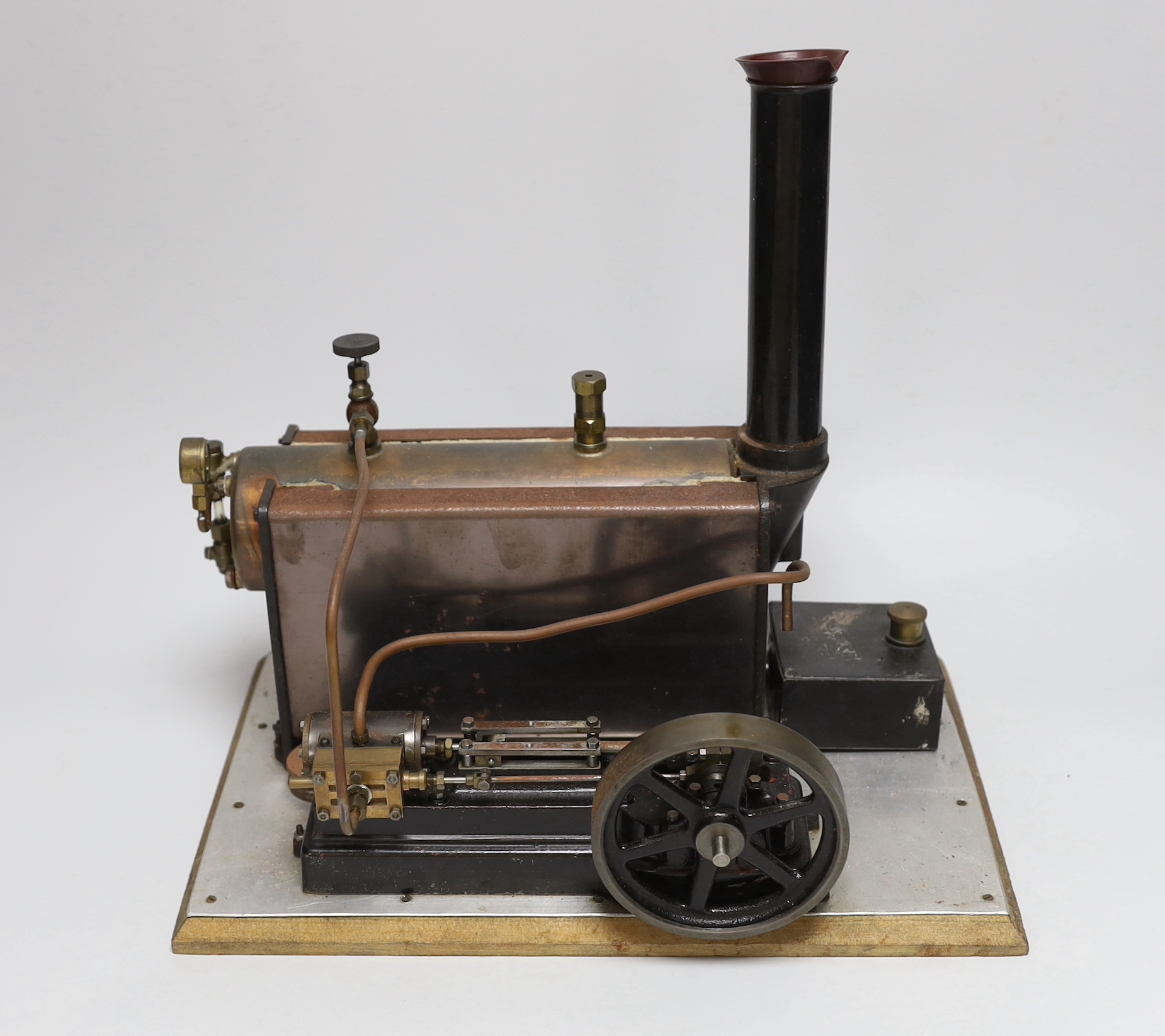 A vintage Stuart Turner model steam engine and boiler mounted on a wooden base, with booklet 33cm wide